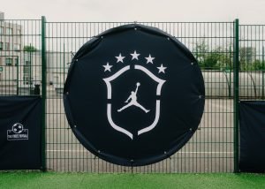 The Jordan Brasil crest banner hung on the pitch fence next to The Streetz Football badge