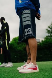 Close up of Jordan 23 denim shorts and pink Jordan trainers on the pitch at the activation