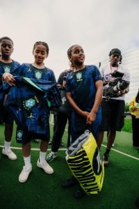 Young players unboxing their Jordan x Brasil kits while a videographer films the activation