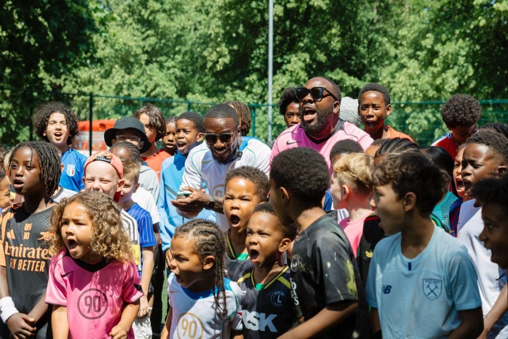 Coach Mali and a large group of young TSF players together at a community football event