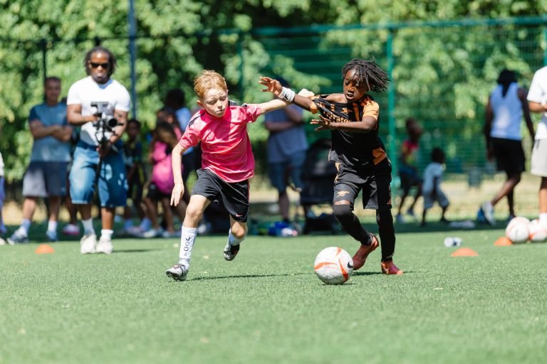 Two young players racing for the ball on the pitch